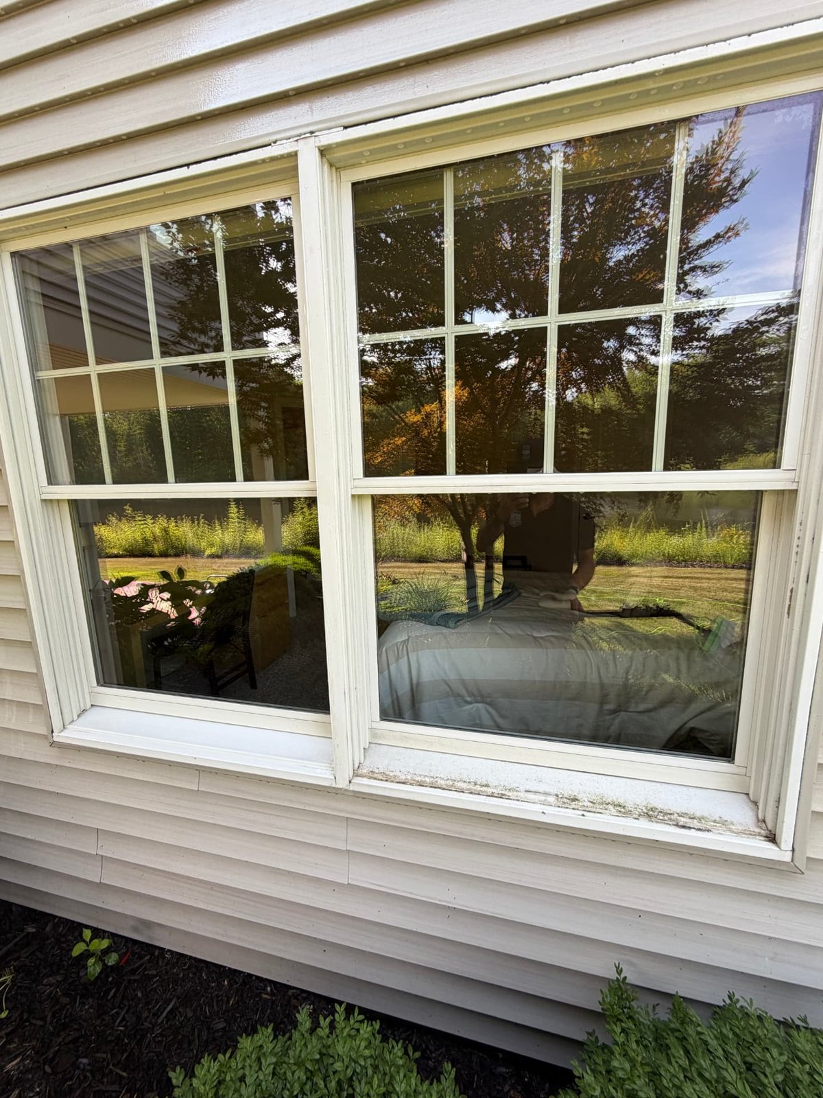 Clean double-hung windows on a white home cleaned by Scrub E Dub